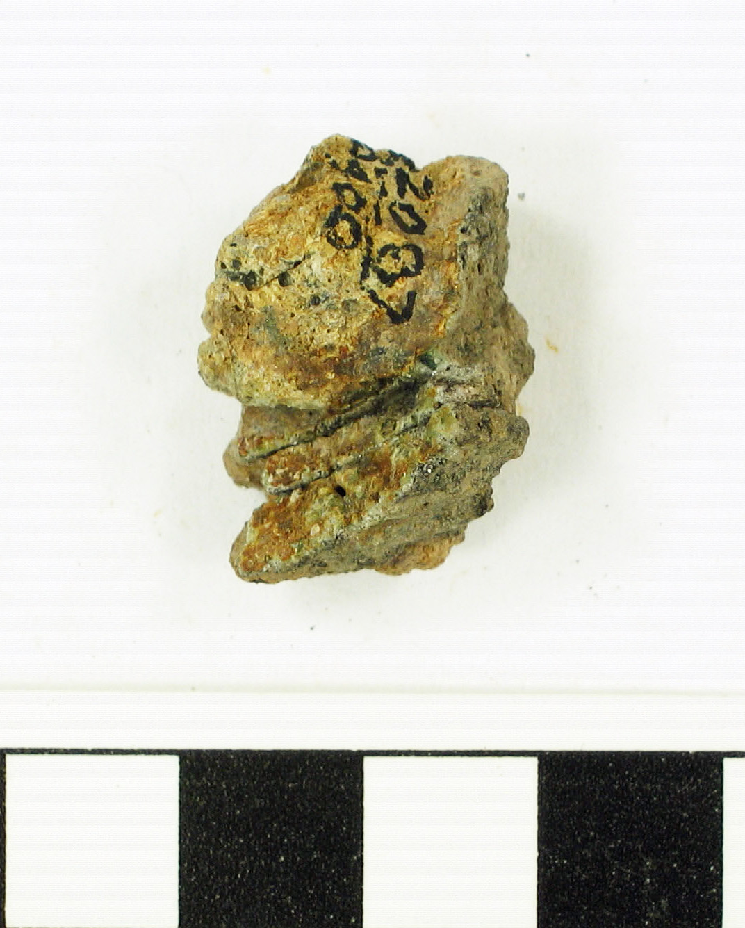 DK 2087/400<br>Body fragment.The piece is vitrified but shows strong surface weathering. The exterior surface is very rough and has mottled colors, but mostly 10YR 6/2, light brownish gray. There is a large rounded vitrified “bubble” or mass on the inside surface, ~1.0 x 1.5cm. The “bubble” is lighter in color, ranging from 10YR 7/4, very pale brown, to 10YR 6/4, light yellowish brown. There is a light greenish white glass on the underside of the bubble where it is separated from the interior surface in a groove ~5.0mm deep, 8.0mm long, and 1.0-2.0mm wide. Remnants of a dark brown glass, 10YR 4/3, line part of the base of the bubble and up onto it at one end. The surface of the bubble is quite frothy in appearance with remnants of small gray, black, and brown glassy bubbles. Temper is quartz sand.